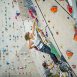 A young lady lead climbing preparing for a Climbing wall Development Instructor course