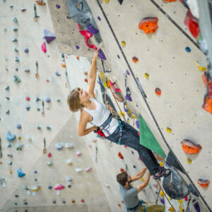 A young lady lead climbing preparing for a Climbing wall Development Instructor course