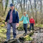 A group walk over stepping stones whilst on a Lowland Leader training course in the peak District.