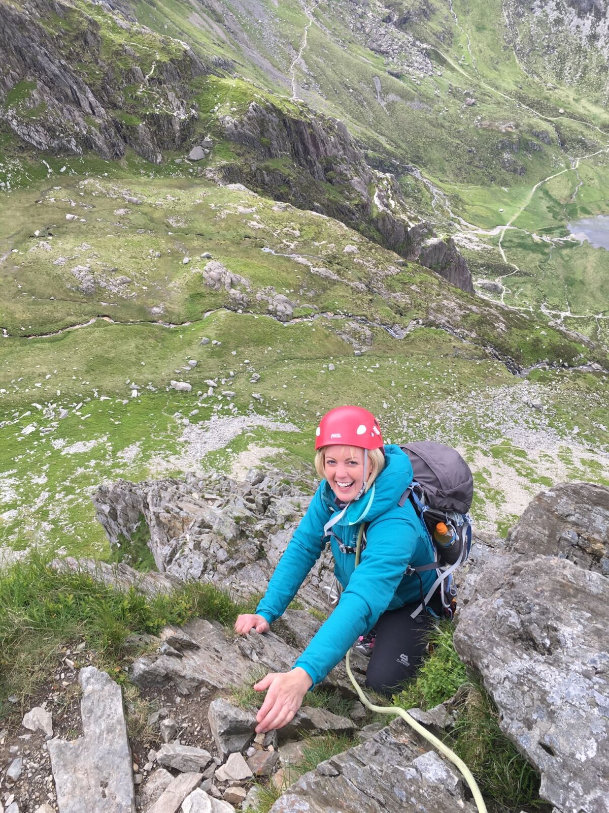 A woman smiling whilst scrambling up Cneifon Arete on an Advanced Scrambling course.