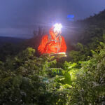 A man walking in bracken at night practicing Advanced navigation.