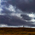A woman navigating with a map and compass on a Hill and Moorland Leader assessment in the Peak District.
