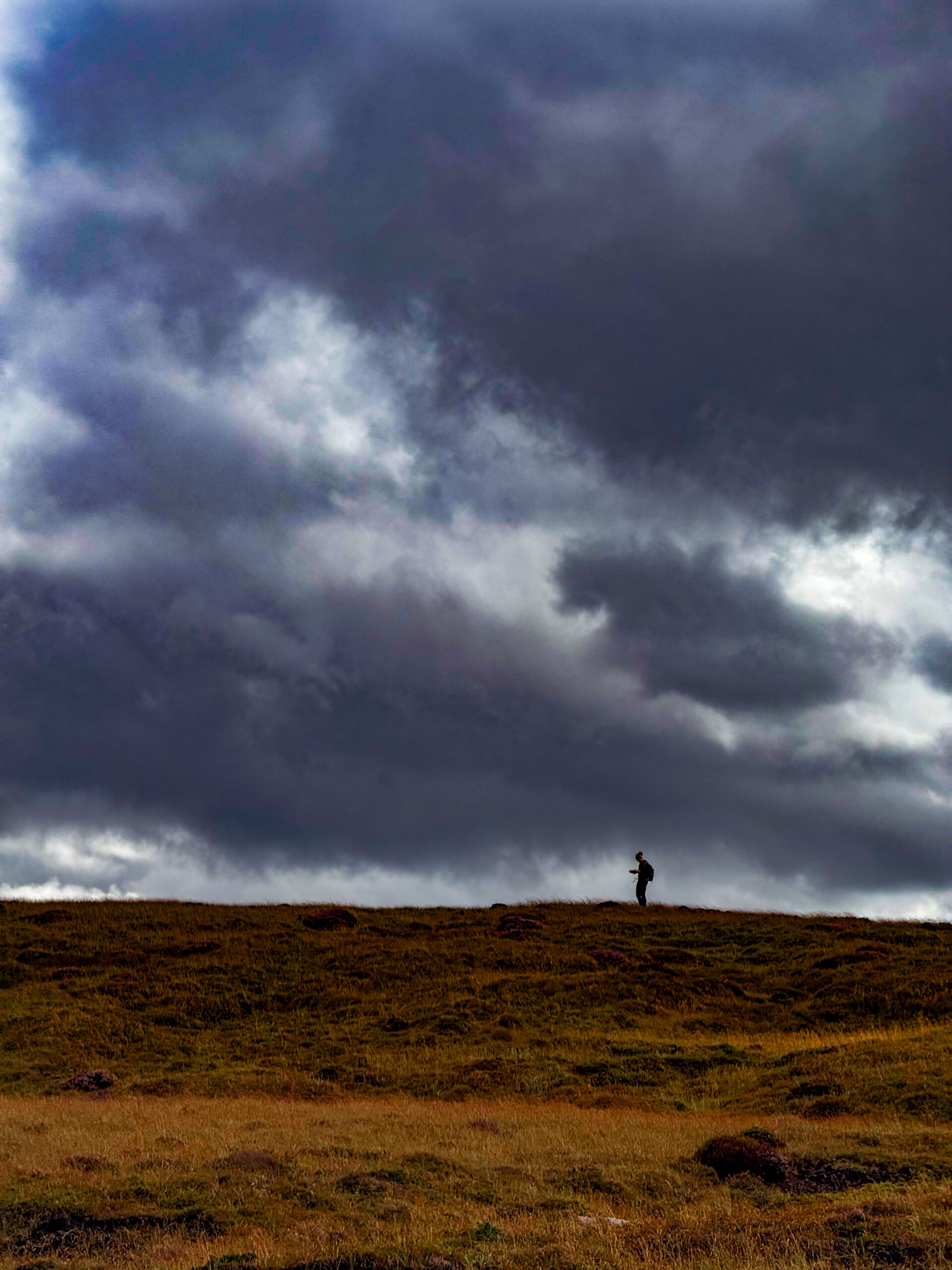 A woman navigating with a map and compass on a Hill and Moorland Leader assessment in the Peak District.