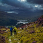 Two men look towards Snowden whilst practicing navigation on a mountain skills course.