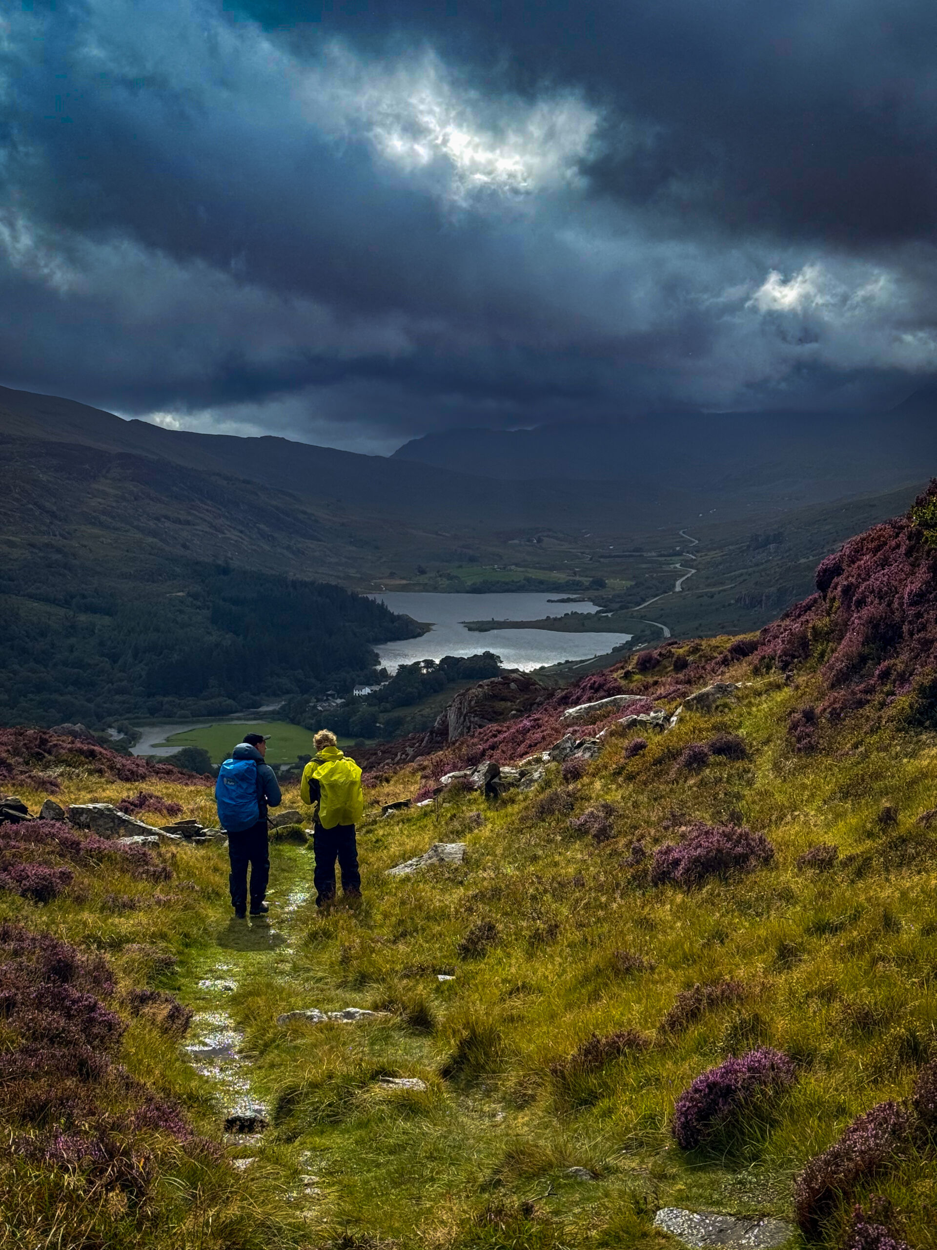 Two men look towards Snowden whilst practicing navigation on a mountain skills course.