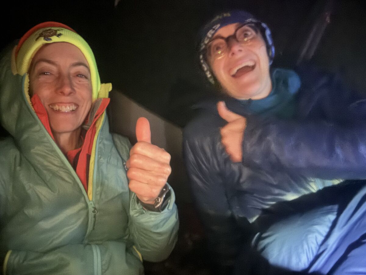 Two women doing a thumbs up in a tent on the OMM