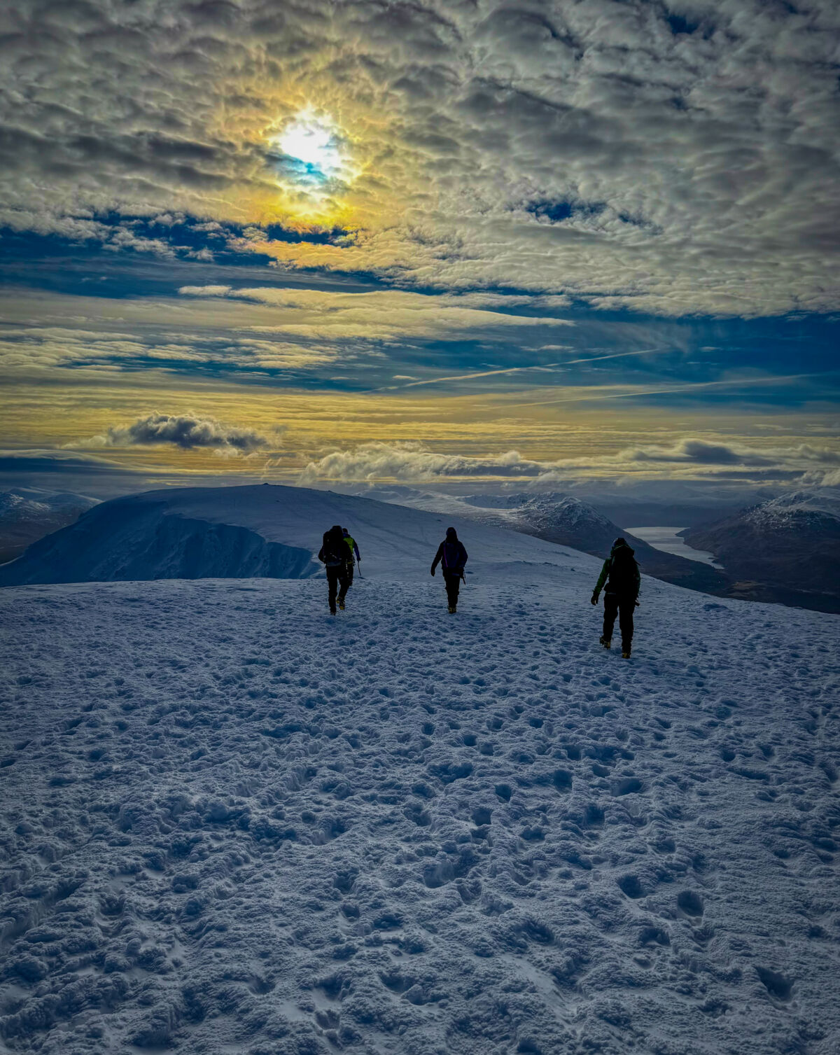 A group descending from the summit whilst on a winter mountaineering course in Scotland.