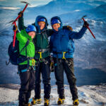 A group of ladies holding ice axes near the summit of Beinn a Chaoriann on a winter mountaineering course.