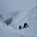 A pair of climbers in Raeburns gully on Creag Megadith whilst on a winter mountaineering course in Scotland.