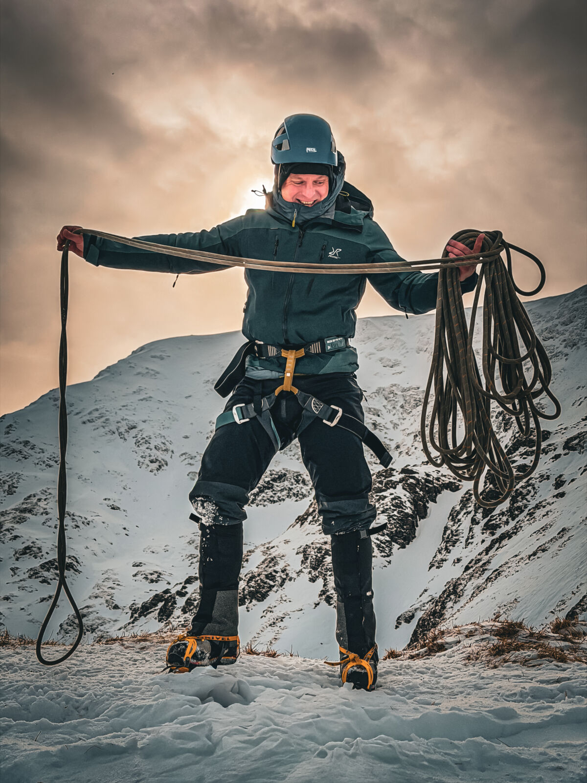 A man coiling a rope on Beinn a Chaiorann on a winter mountaineering course in Scotland