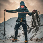 A man coiling a rope on Beinn a Chaiorann on a winter mountaineering course in Scotland