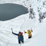 Two climbers climbing a gully in Scotland on a winter climbing course.