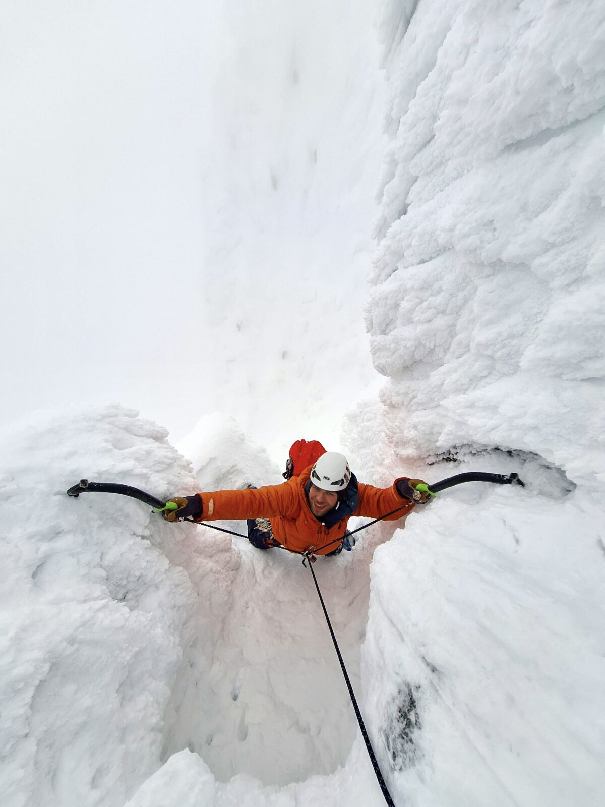 A man climbing steep ice on The Seam in Coire Snaechda whilst on a winter Climbing course in Scotland.