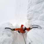 A man climbing steep ice on The Seam in Coire Snaechda whilst on a winter Climbing course in Scotland.