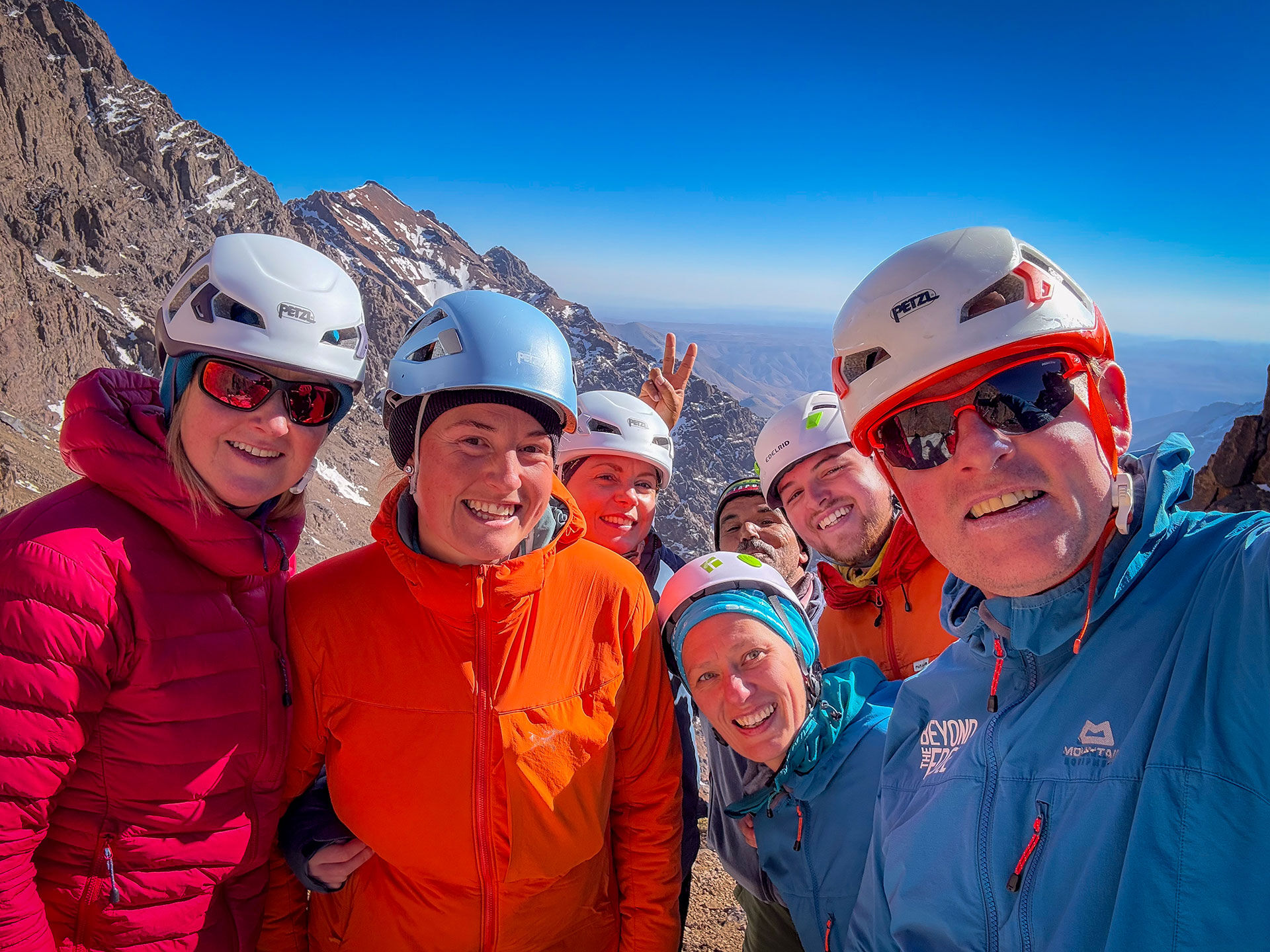 A happy smiling group winter mountaineering on Toubkal in Morocco.