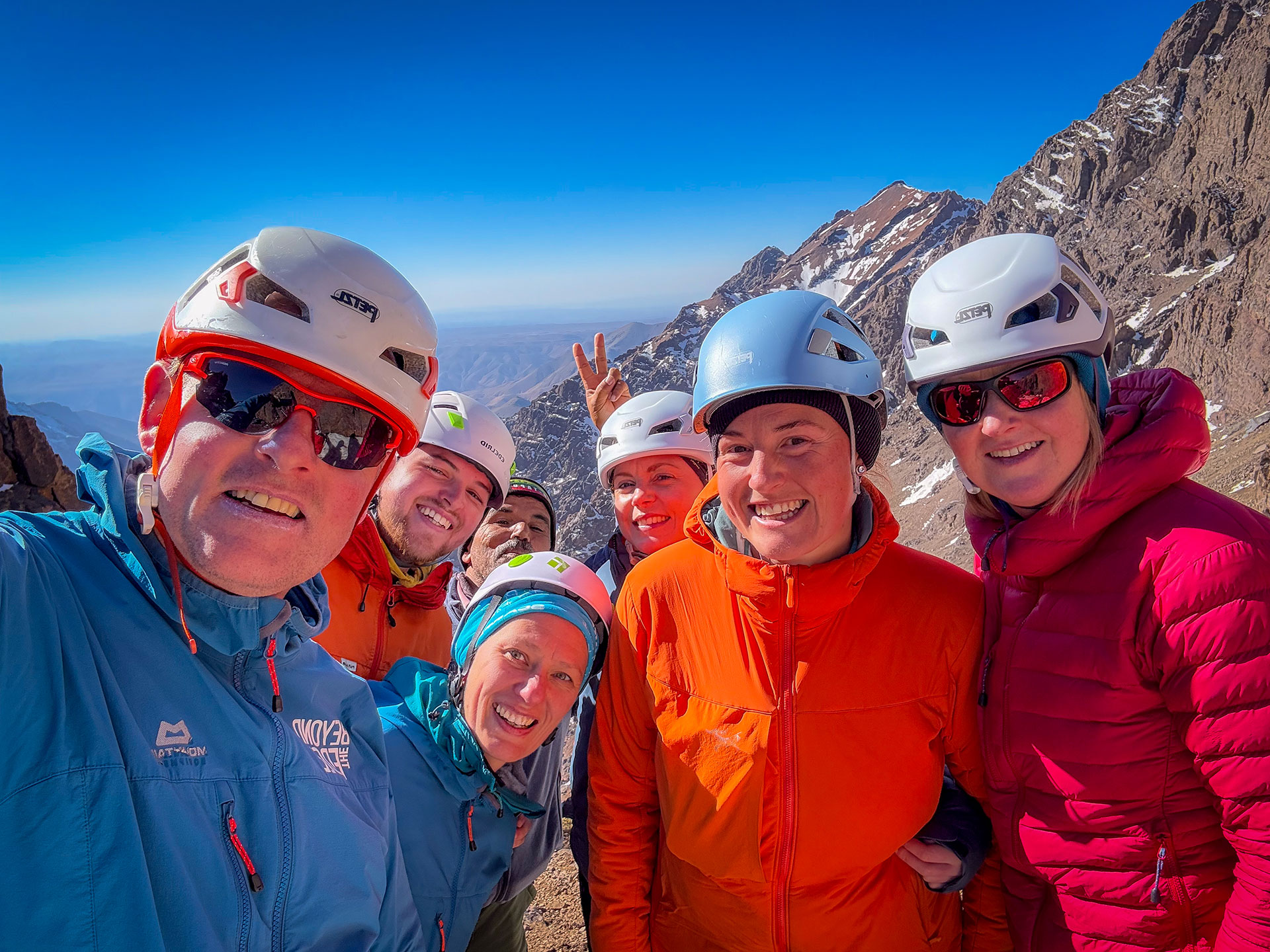 A happy smiling group winter mountaineering on Toubkal in Morocco.